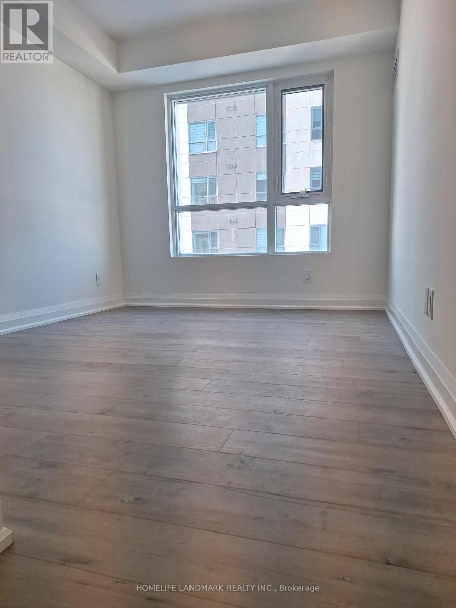 A room with wooden flooring and a large window.