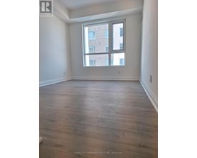 A room with wooden flooring and a large window.