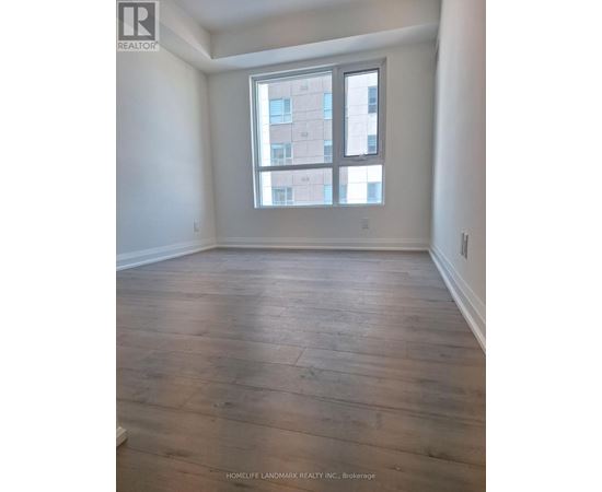 A room with wooden flooring and a large window.