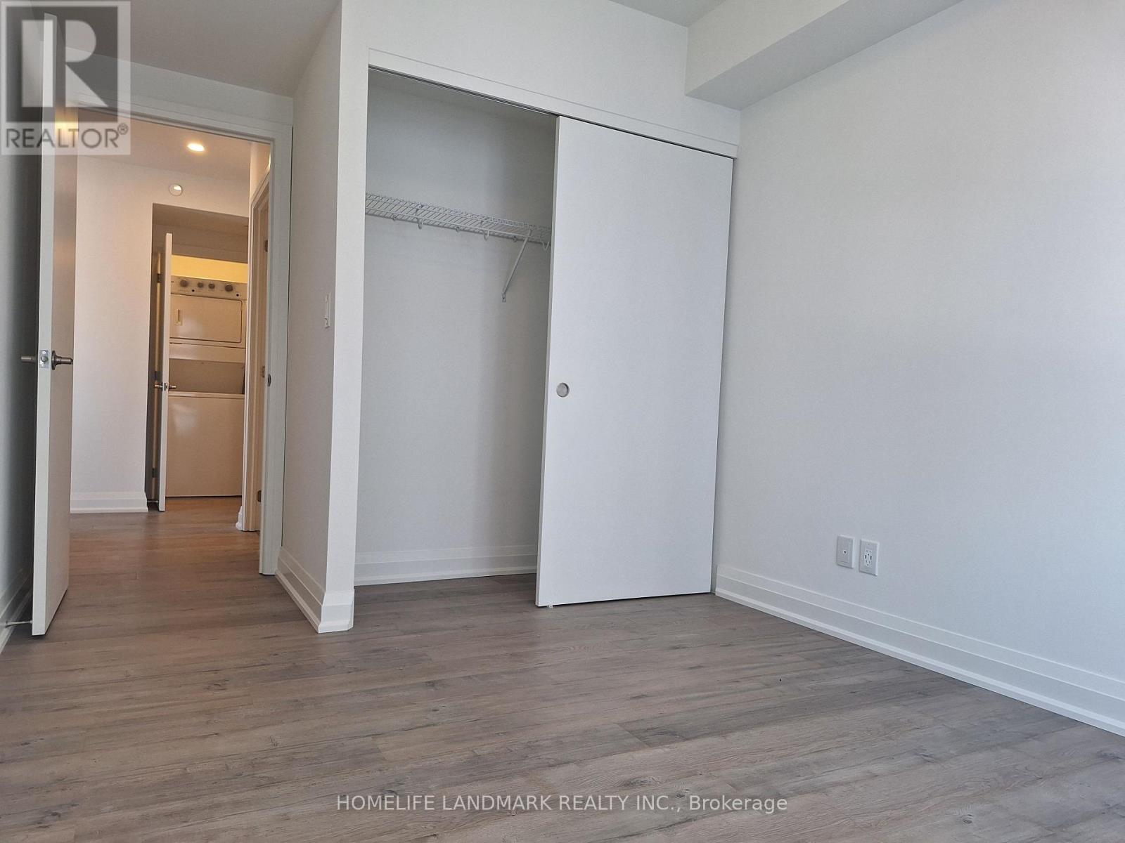 A room with a white wall and a wooden floor.