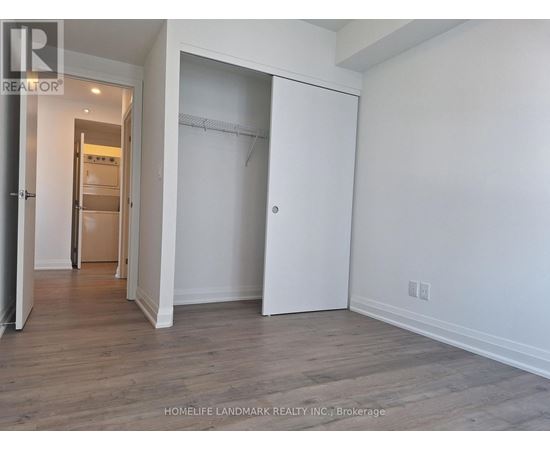 A room with a white wall and a wooden floor.