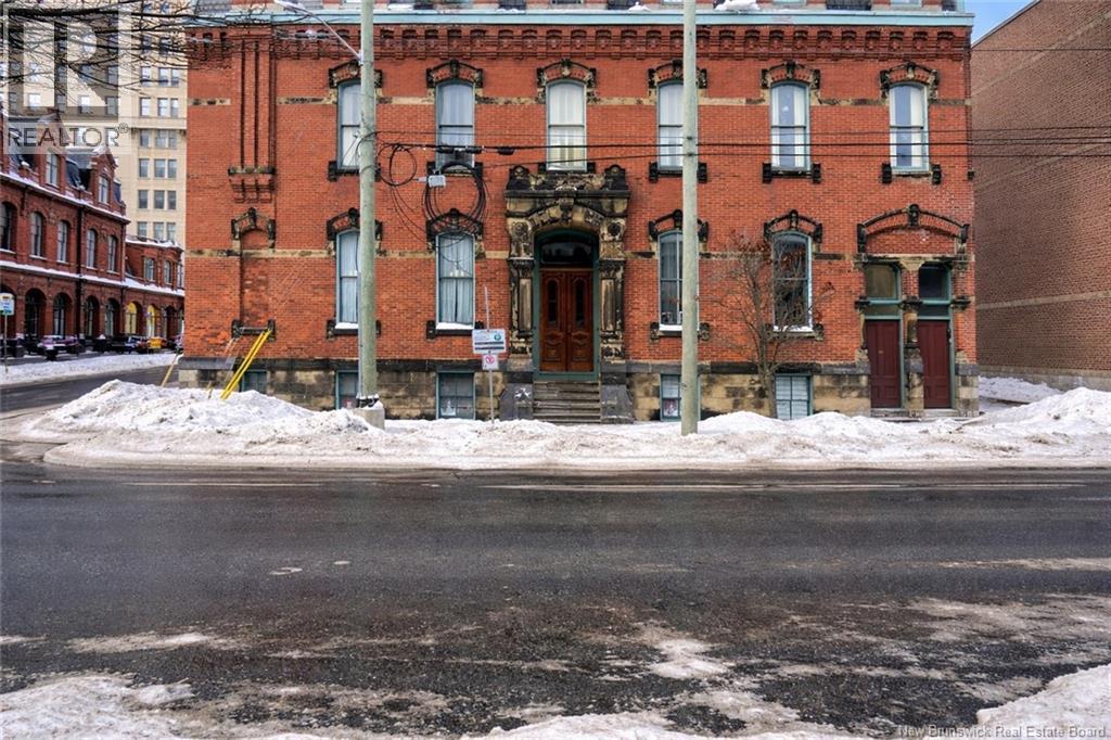 A red brick building with a large door and windows.