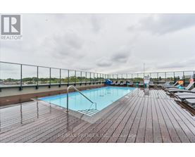 A pool surrounded by a wooden deck with chairs on it.
