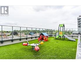 A playground with a slide, swings, and a ball is on a rooftop.