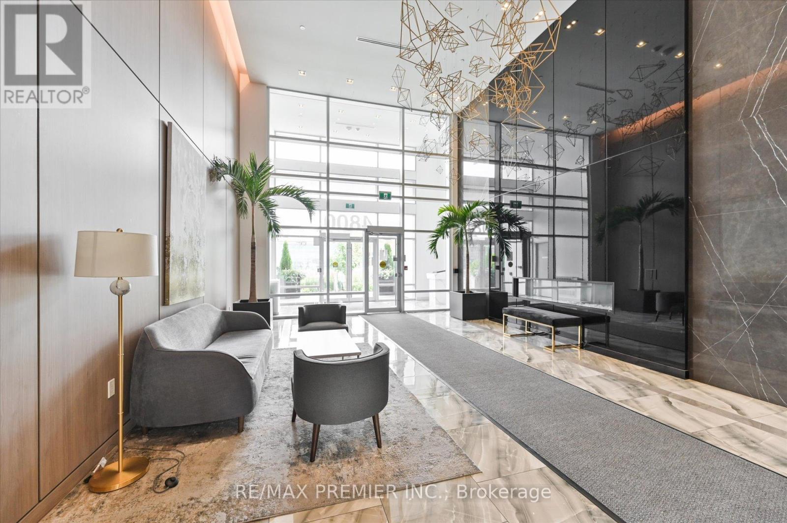 A modern living room with a grey sofa and a wooden floor.