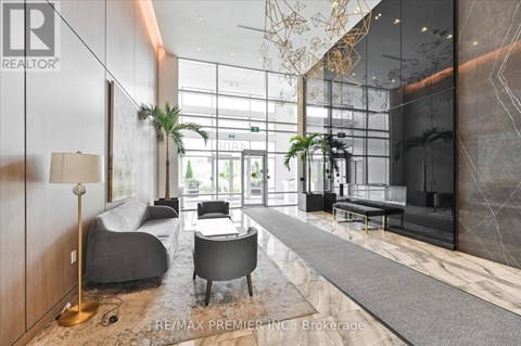 A modern living room with a grey sofa and a wooden floor.