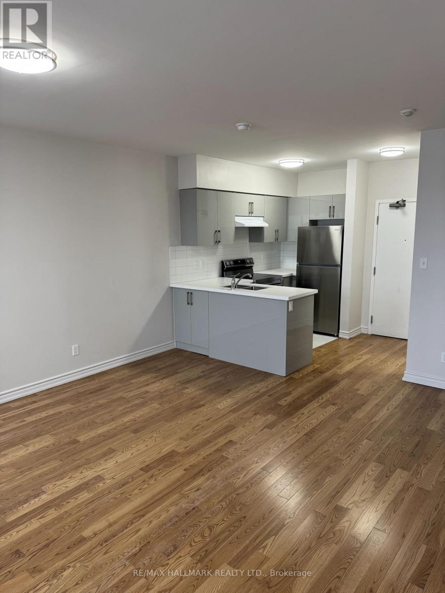 A kitchen with white cabinets and a wooden floor.