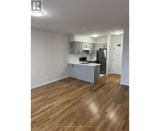 A kitchen with white cabinets and a wooden floor.