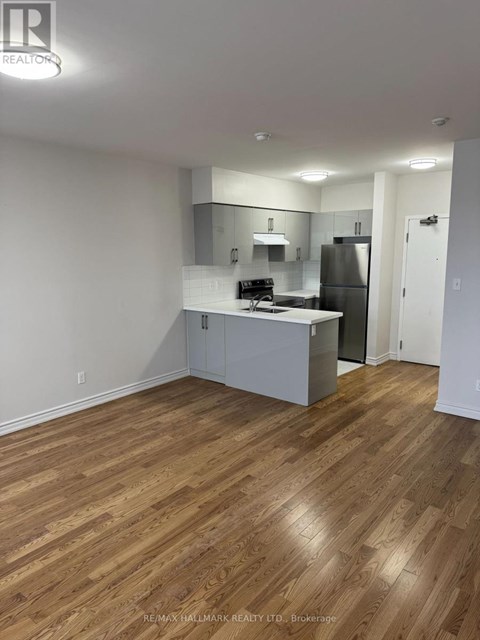 A kitchen with white cabinets and a wooden floor.