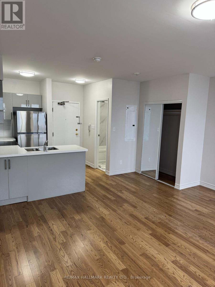 A large open room with wood flooring and white walls.
