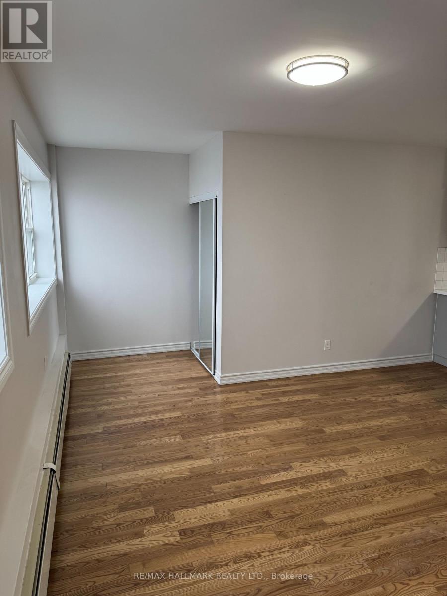 A room with wooden flooring and white walls.