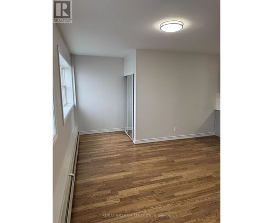A room with wooden flooring and white walls.