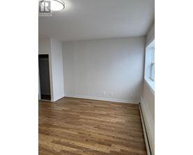A room with wooden flooring and white walls.