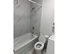 A white toilet in a bathroom with marble tiles.