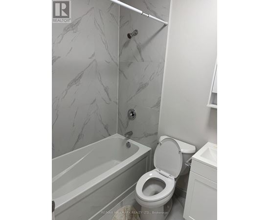 A white toilet in a bathroom with marble tiles.