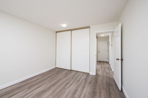 A room with a white wall and a wooden floor.