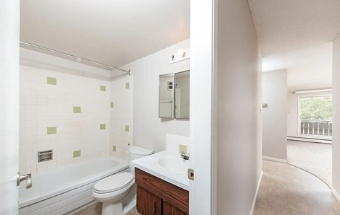 A bathroom with a tub, toilet and sink.