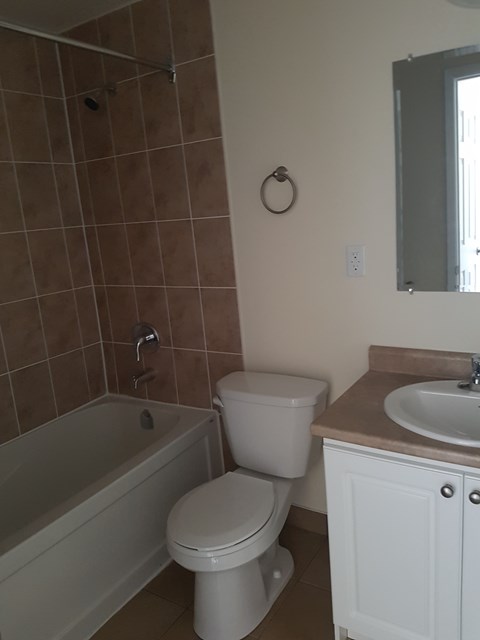 A white toilet sits next to a sink in a bathroom.