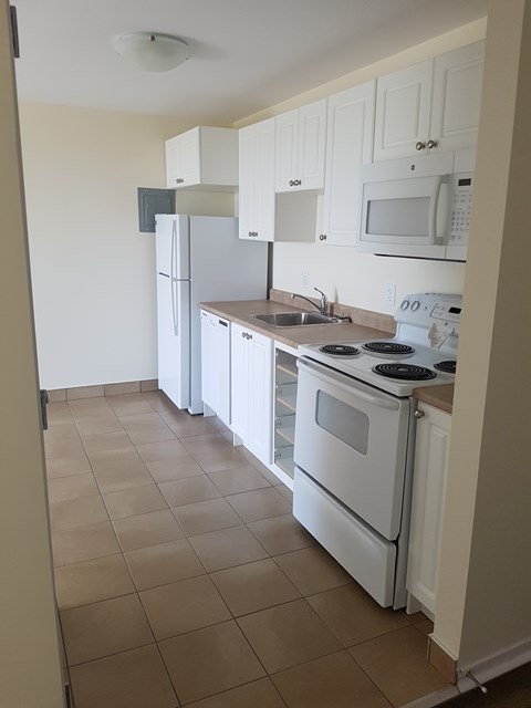 A kitchen with white appliances and cabinets.