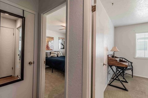A bedroom with a bed, a chair, and a table.