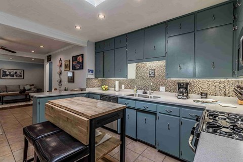 A kitchen with a wooden table and blue cabinets.
