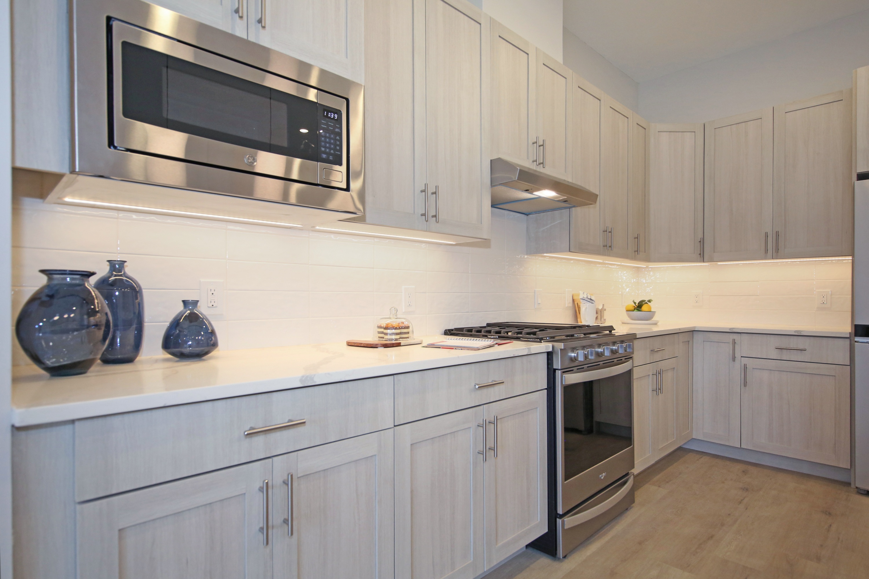 A kitchen with a stainless steel microwave above the stove.