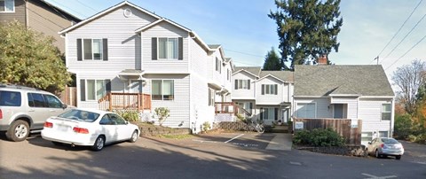 A white car is parked in front of a house.