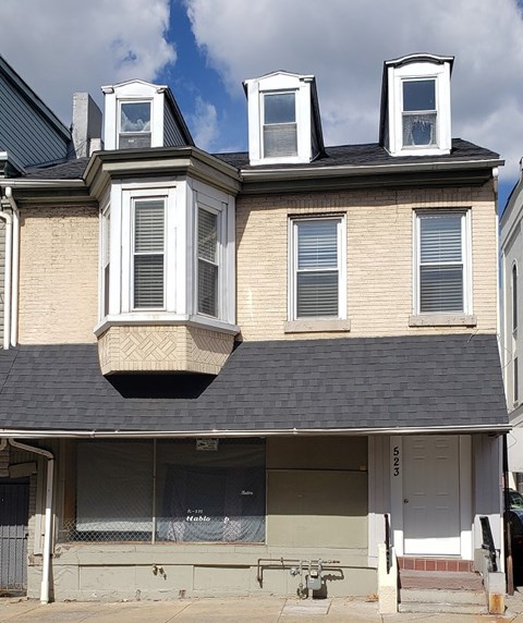 A two-story house with a grey roof and white trim.