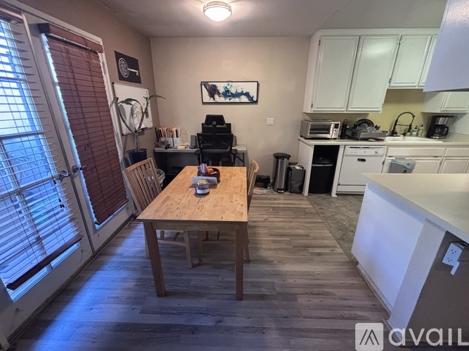 A kitchen with a table and chairs in front of a window.