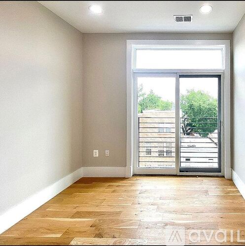 A room with a sliding glass door leading to a balcony.