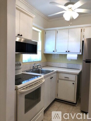 A kitchen with white cabinets and appliances.