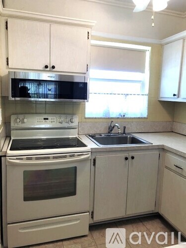 A kitchen with white appliances and cabinets.