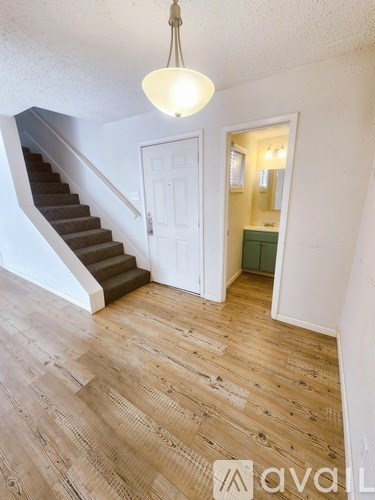 A wooden floor leads up to a white door.
