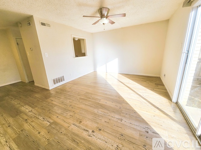 A room with wooden flooring and a ceiling fan.