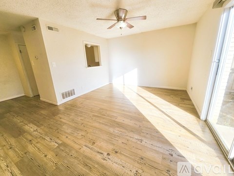 A room with wooden flooring and a ceiling fan.