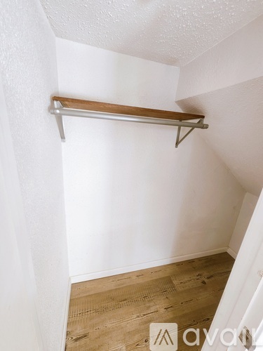 A white wall with a wooden shelf on top.