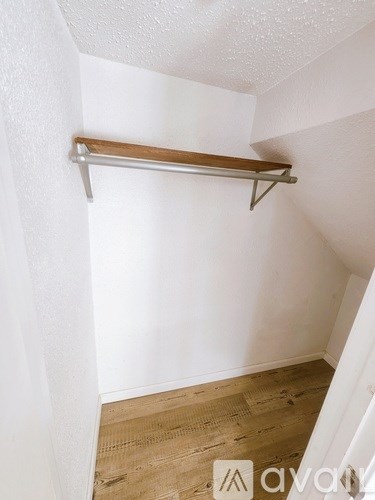 A white wall with a wooden shelf on top.
