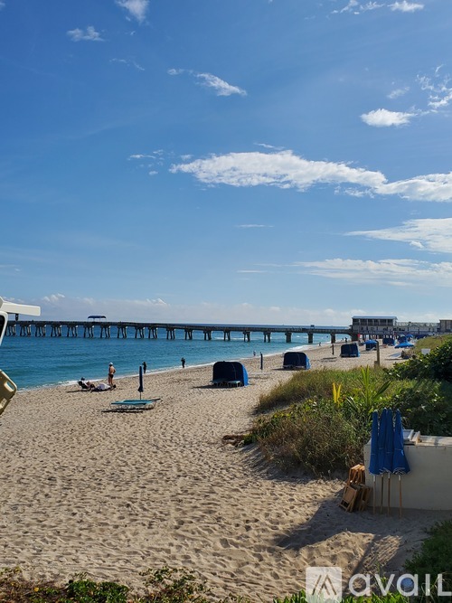 A beach scene with a pier in the distance.