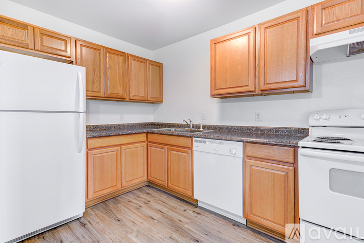A kitchen with wooden cabinets and white appliances.