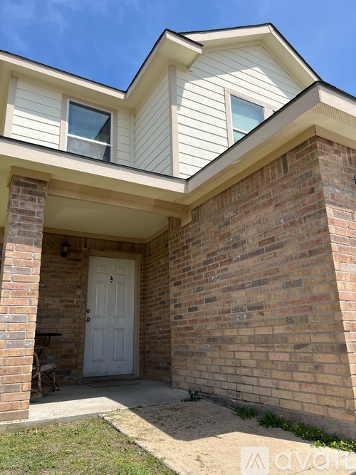 A house with a white door and a brick wall.