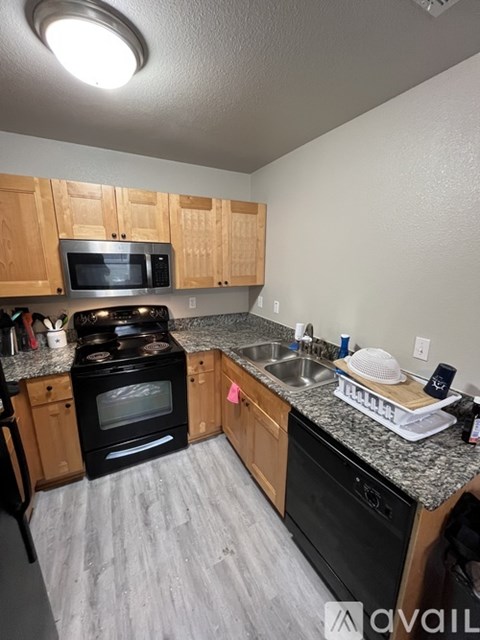 A kitchen with wooden cabinets and black appliances.