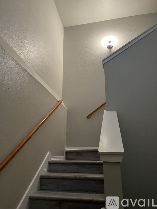 A staircase with a light on the wall.