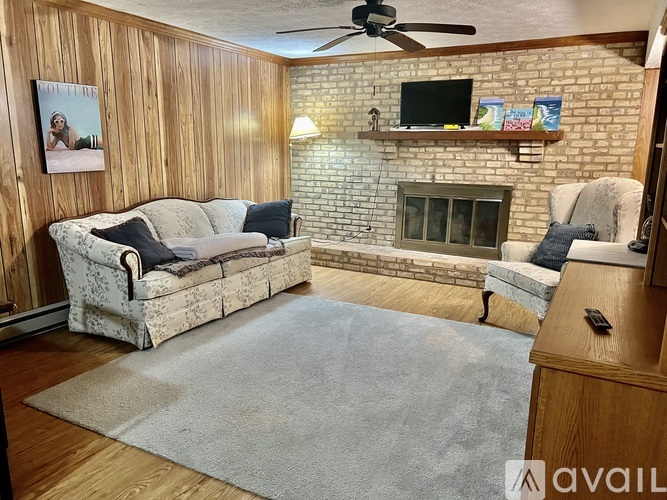 A living room with a couch, a fireplace, and a television.