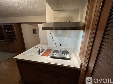 A kitchen with a sink and stove top.
