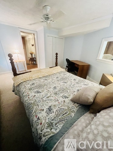 A bedroom with a large bed and a ceiling fan.