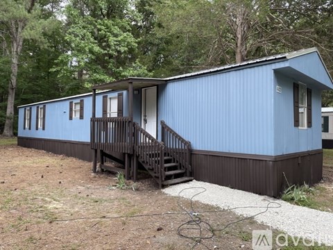 A blue house with a brown porch and a white door.