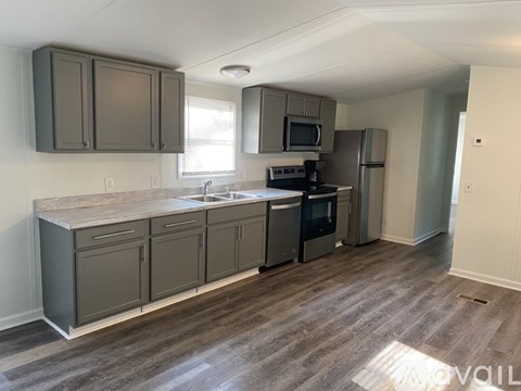 A kitchen with a refrigerator, microwave, and oven.