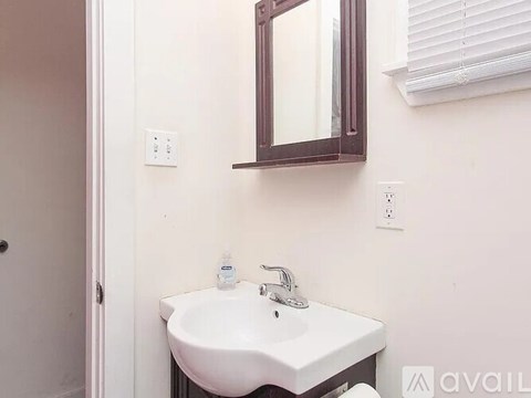 A white sink with a brown mirror above it.