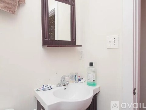 A white sink with a brown mirror above it.