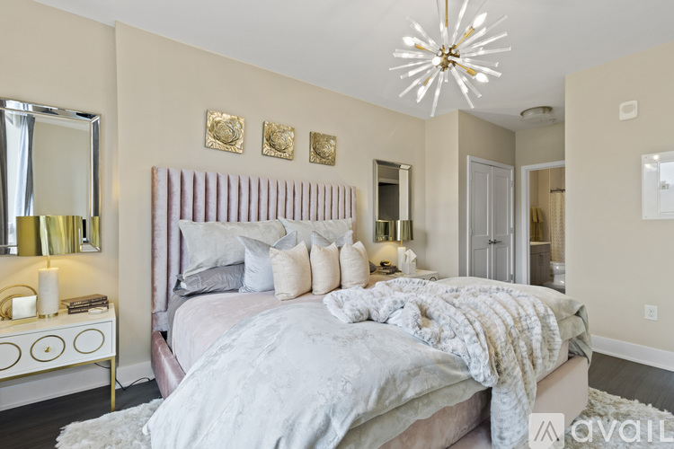 A bedroom with a large bed and a chandelier.